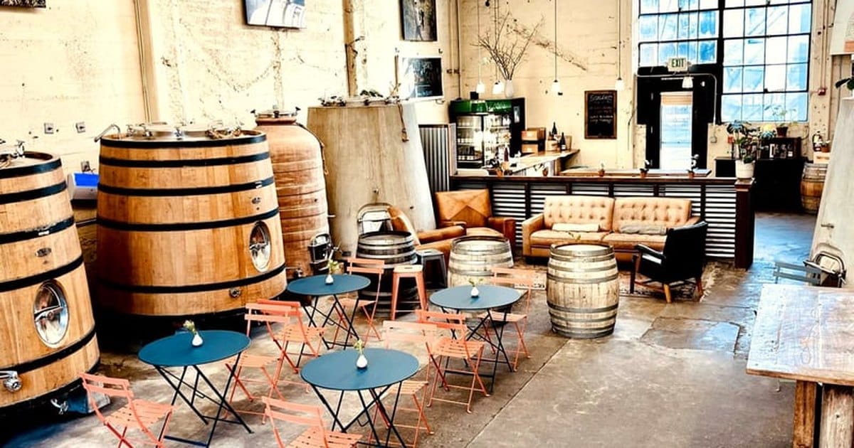 Industrial Chic Winery in Northwest Berkeley with large wine barrels, bistro tables, leather sofas and tall factory windows