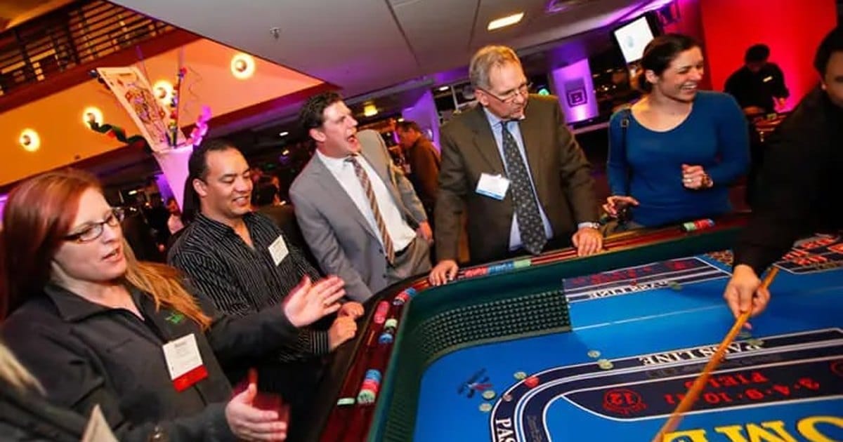 Coworkers in business attire cheering around a hosted casino dice table, a holiday party entertainment option for Bay Area offices
