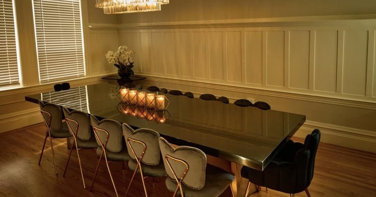 Private dining room in San Francisco with a long dining table, brass-framed chairs and a chandelier