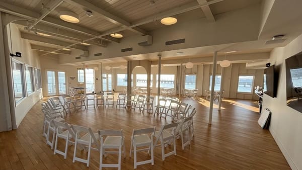 White folding chairs set in a circle inside a waterfront event venue on San Francisco Bay, bookable on Events in Minutes