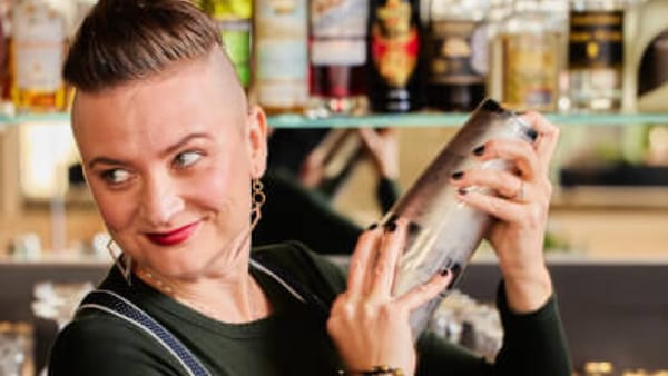 A bartender shakes a cocktail during a hands-on indoor mixology team building class in the Bay Area