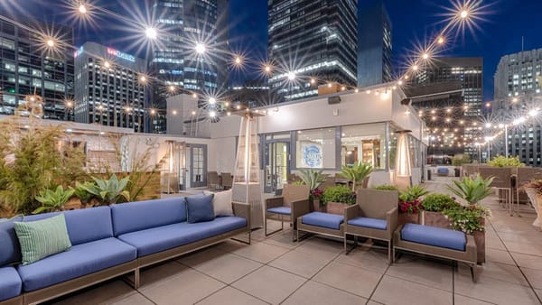 Rooftop event venue in downtown San Francisco set up for an evening reception with string lights and skyline views