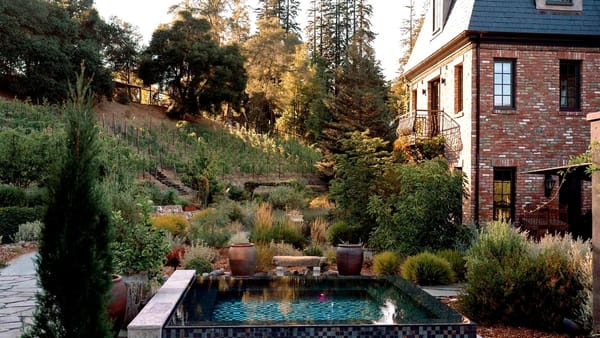 Brick estate wedding venue in Los Gatos with terraced hillside vineyard and gardens at sunset