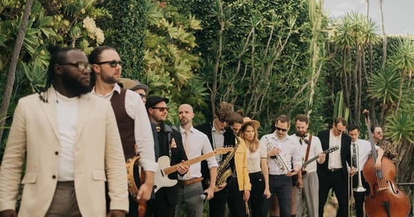 Bay Area corporate event band posed with a saxophone, guitars and an upright bass in front of a green living wall