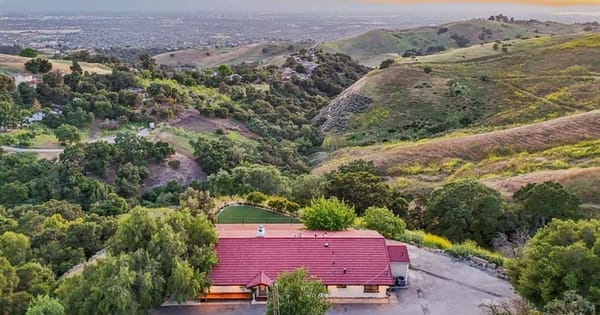 Aerial view of a red-roofed hillside estate event venue in San Jose's East Foothills above the Santa Clara Valley at sunset