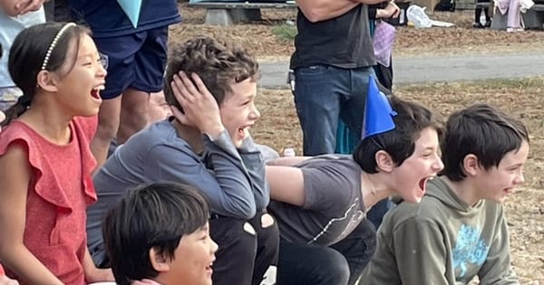 Children laughing and reacting during an outdoor magic show