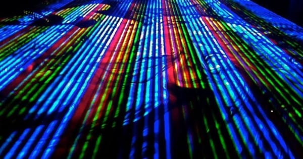 Blue, green and red laser lines projected across a dark surface